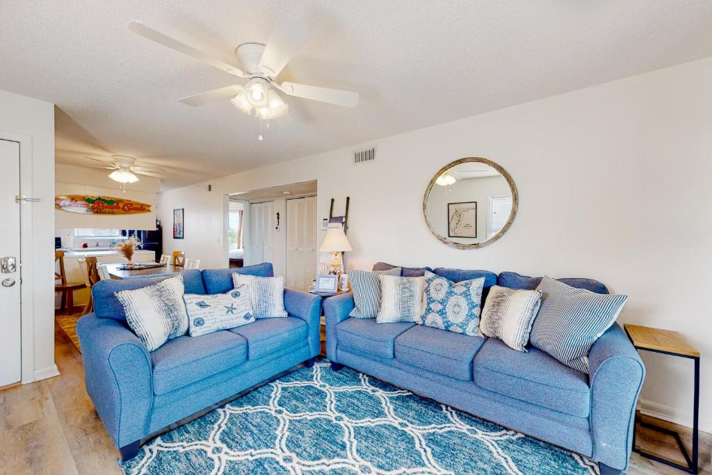 sala de estar con 2 sofás azules y ventilador de techo en Villas on the Gulf H10 en Pensacola Beach