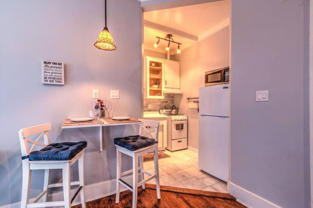 cocina con nevera blanca y mesa con taburetes en Splendid Colonial in Midtown with Parking, en Memphis