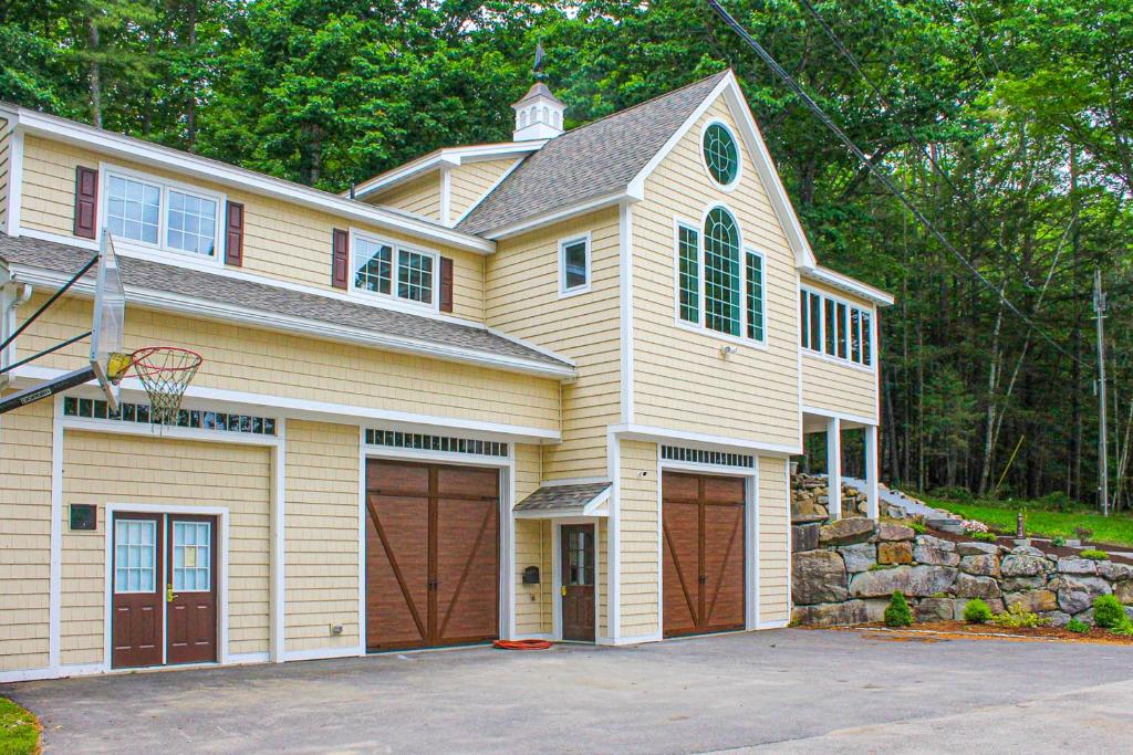 a house with two garage doors and a basketball hoop at Stoneybrook Retreat Haven - The Carriage House in State Landing