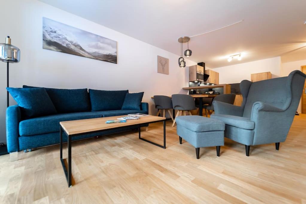 ein Wohnzimmer mit einem Sofa, Stühlen und einem Tisch in der Unterkunft Ferienwohnung Feldberg Schwarzwald in Feldberg