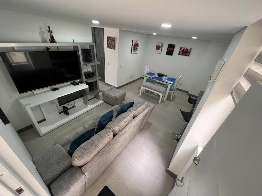 sala de estar con sofá y TV de pantalla plana en Edificio apartamentos central con ascensor 502, en Bogotá