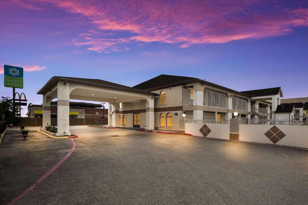 an empty parking lot in front of a hotel at SureStay Hotel by Best Western Deer Park in Deer Park