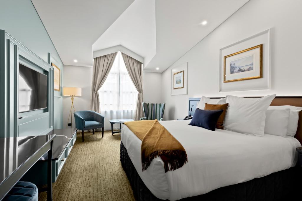 ein Hotelzimmer mit einem Bett und einem TV in der Unterkunft Millennium Hotel Queenstown in Queenstown