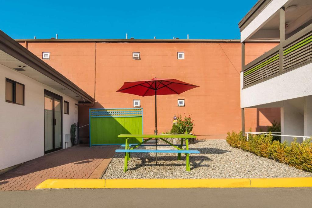 a picnic table with an umbrella in front of a building at SureStay Hotel by Best Western North Vancouver Capilano in North Vancouver