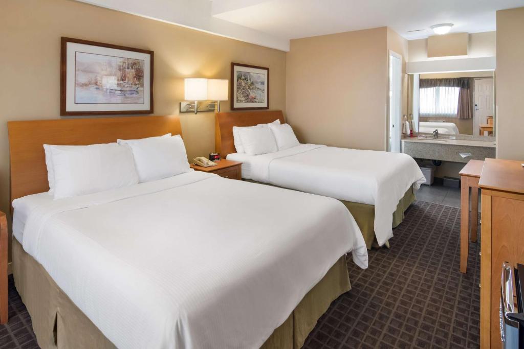 a hotel room with two beds and a bathroom at SureStay Hotel by Best Western North Vancouver Capilano in North Vancouver