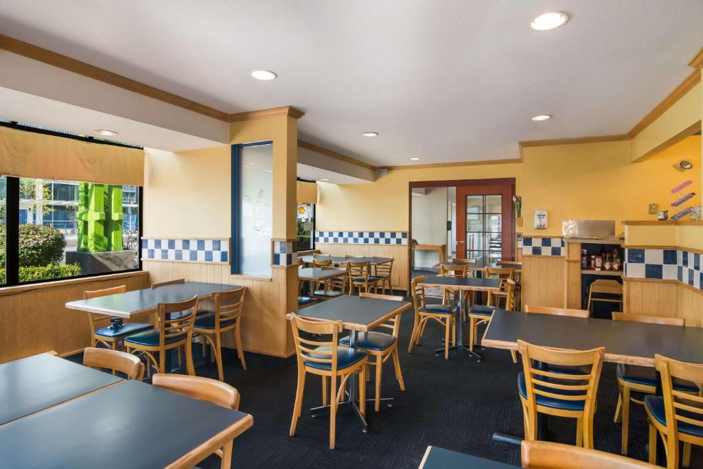 a restaurant with tables and chairs in a cafeteria at SureStay Hotel by Best Western North Vancouver Capilano in North Vancouver