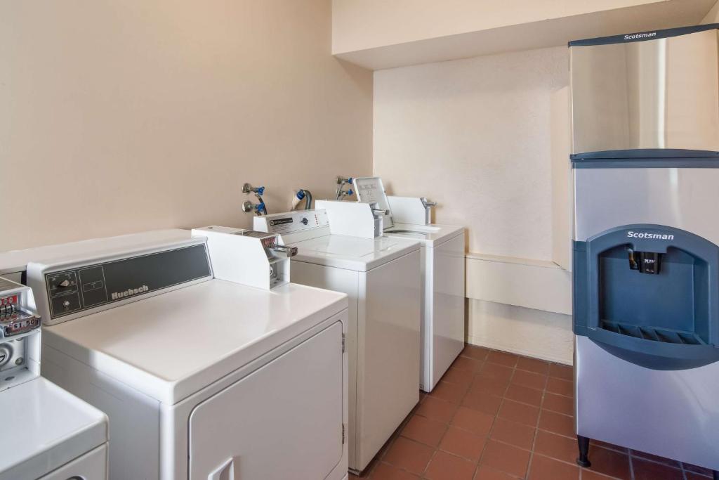 a kitchen with white appliances in a room at SureStay Hotel by Best Western North Vancouver Capilano in North Vancouver