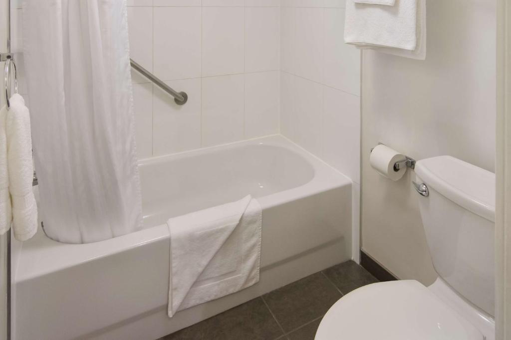 a white bathroom with a white tub and a toilet at SureStay Hotel by Best Western North Vancouver Capilano in North Vancouver