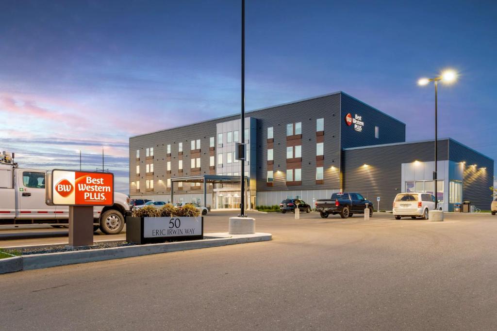 a building with a sign in a parking lot at Best Western Plus Dauphin in Dauphin