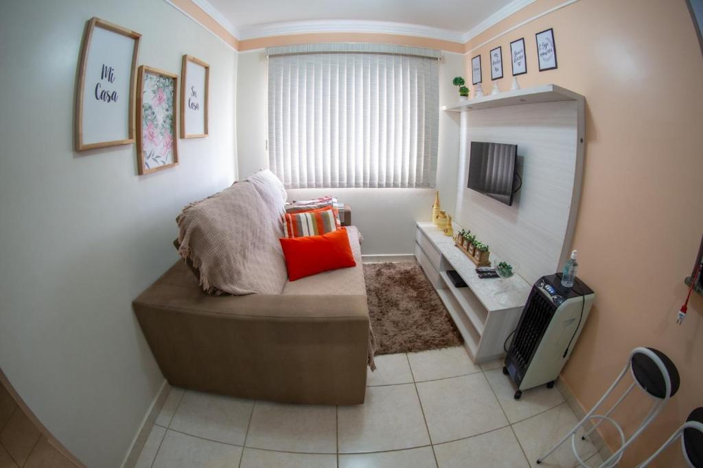 uma sala de estar com um sofá e uma televisão em Apartamento Mari 1 em São Carlos