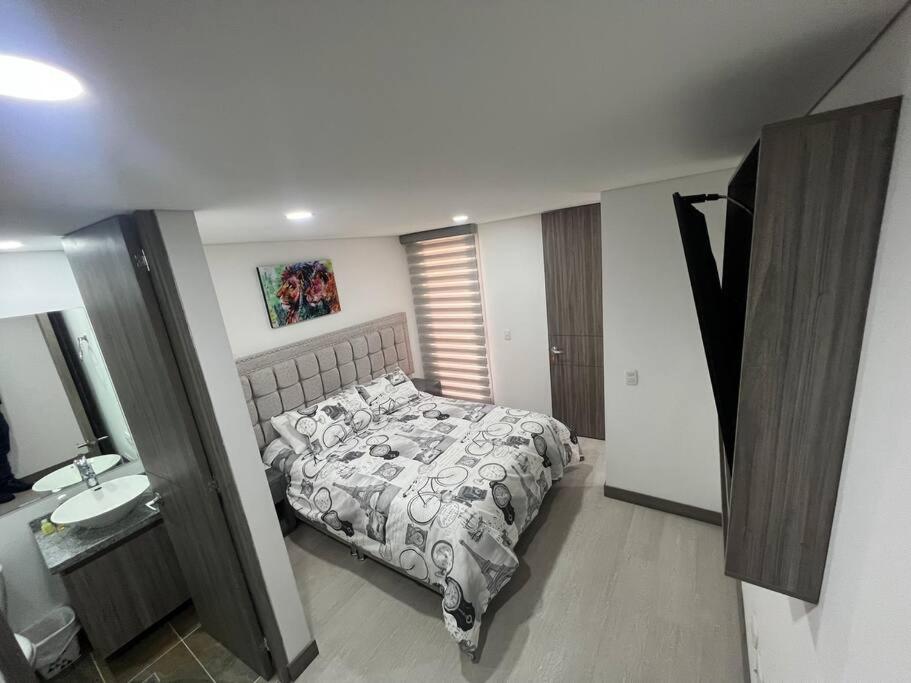 1 dormitorio con 1 cama y lavamanos. en Edificio de Apartamentos central con ascensor. 601, en Bogotá