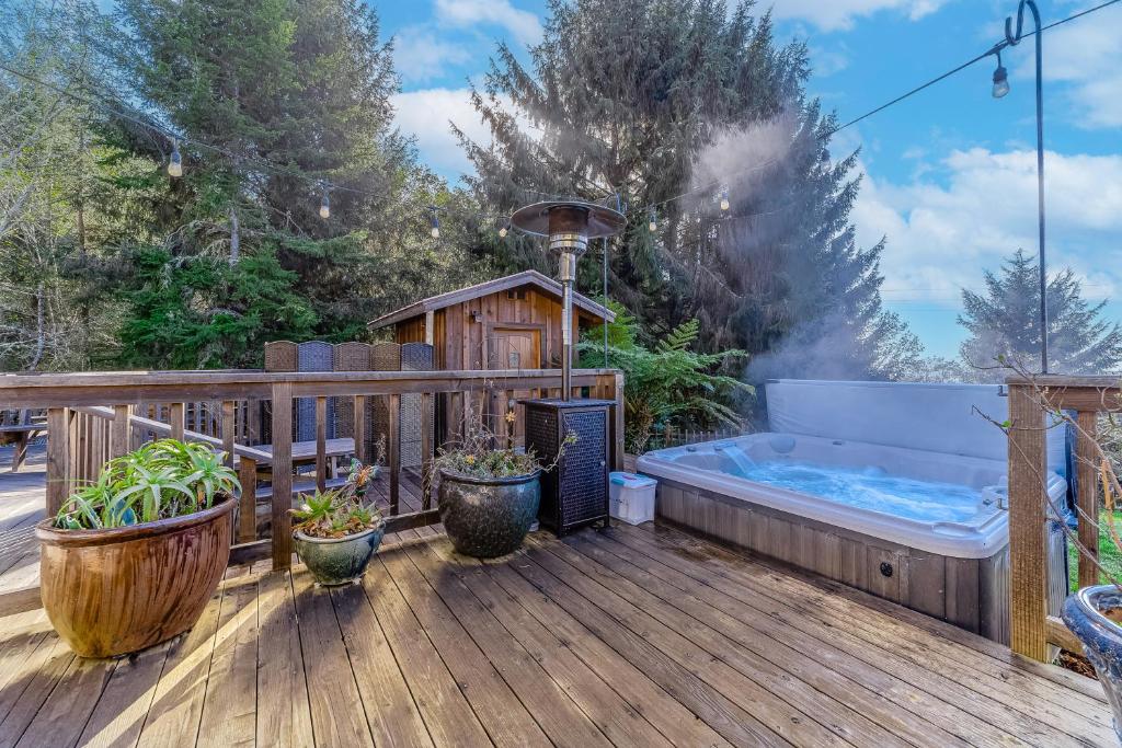 a hot tub on a wooden deck with a hot tub at Zen Lodge in Fortuna