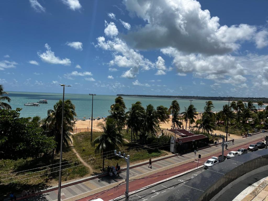 vistas a una carretera con palmeras y al océano en Flat beira mar Tambaú, en João Pessoa