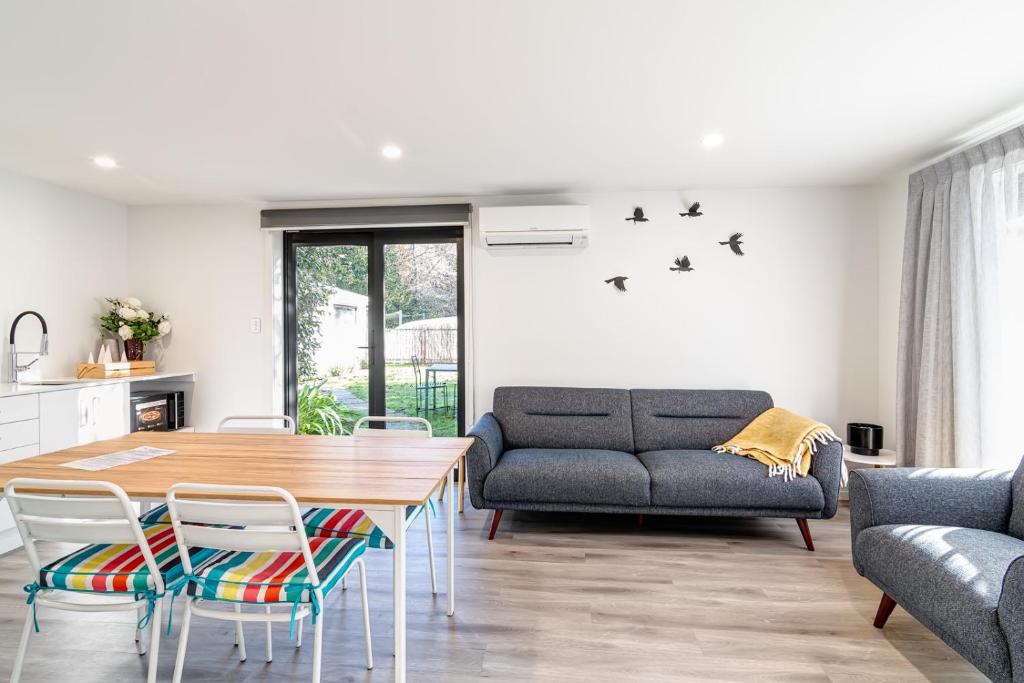 a living room with a table and chairs and a couch at Blue House on the Quay in Motueka