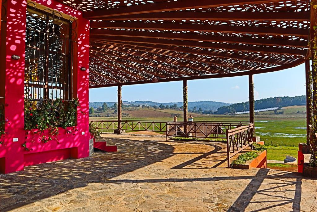 a red pergola with a table and a bench at MASIA ARAMENI in Umecuaro