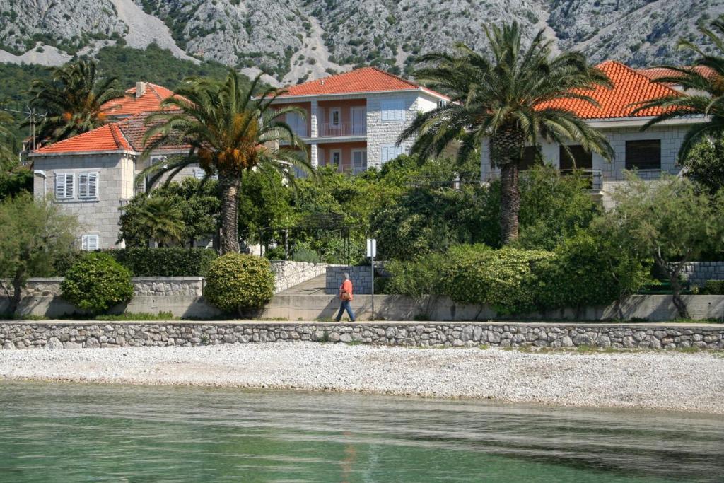 un homme se promenant sur la plage près de l'eau dans l'établissement Apartments by the sea Orebic, Peljesac - 10436, à Orebić