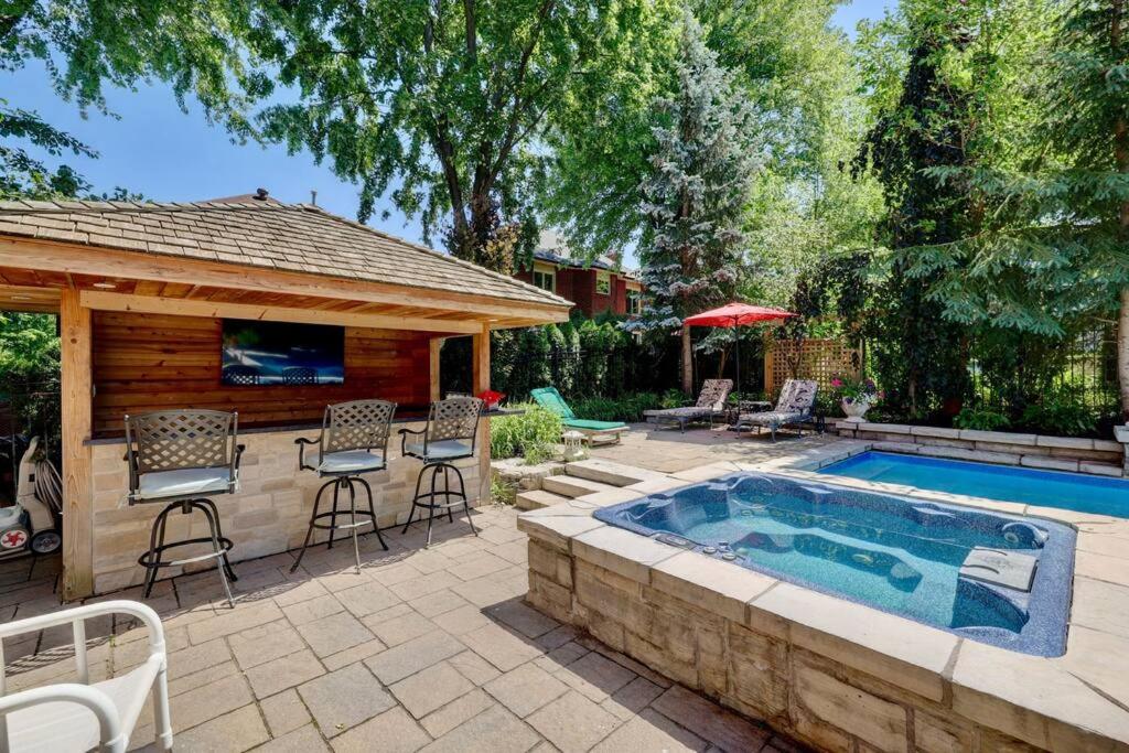 un patio trasero con piscina y cenador en Cheerful 7 bedrooms Villa with Hot tub & Pool. en Mississauga