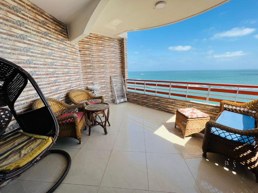 een balkon met stoelen en uitzicht op de oceaan bij شقق عالبحر مباشر فندقيه بميامي in Alexandrië