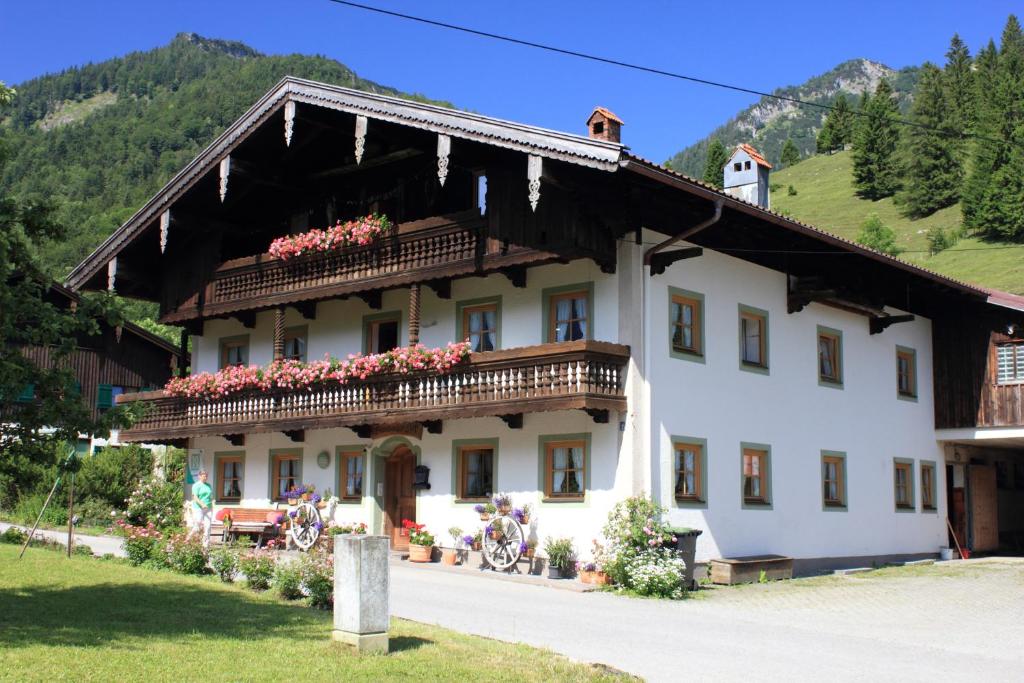 a large white building with flowers on the balcony at Bauernhof Hamberger Hof in Sachrang