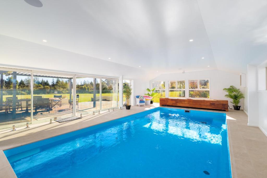 a large swimming pool with blue water in a house at The Meadows Villa in Christchurch