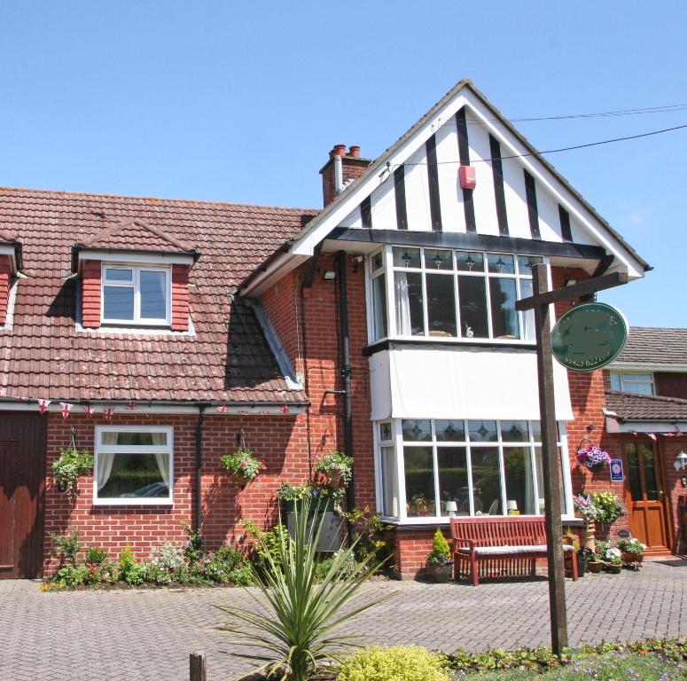 a red brick house with a white at Beech Lodge Guest House in New Milton