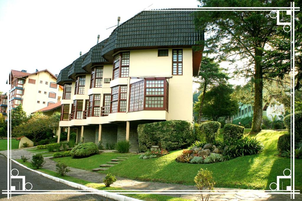 uma grande casa branca com um telhado preto em Vista Real Residence em Gramado