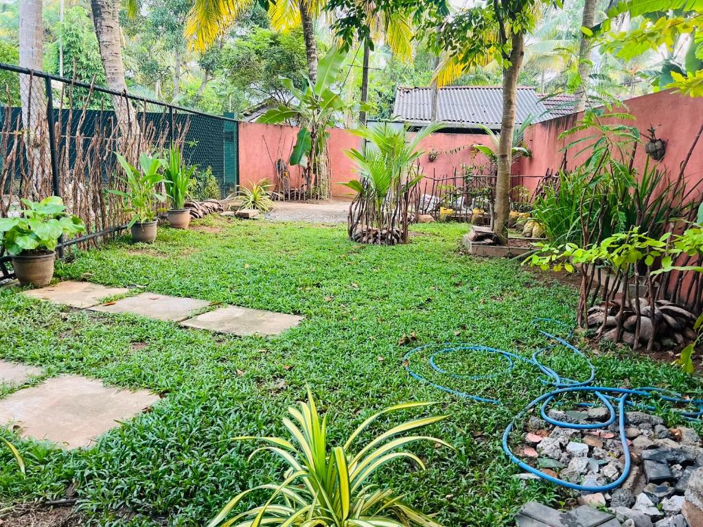 a garden with a hose laying on the grass at Tiny Palace Madihe in Matara