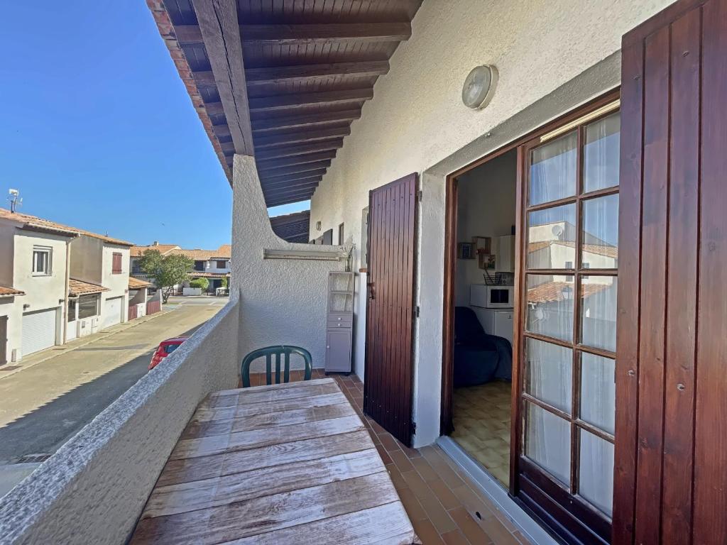 uma varanda de uma casa com piso em madeira em Appartement Saintes-Maries-de-la-Mer, 2 pièces, 4 personnes - FR-1-475-84 em Saintes-Maries-de-la-Mer