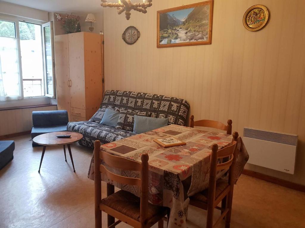 a living room with a table and a couch at Appartement Cauterets, 2 pièces, 4 personnes - FR-1-234-299 in Cauterets