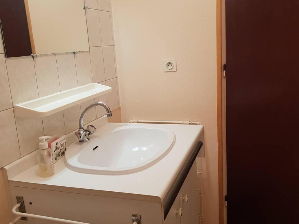 a bathroom with a white sink and a mirror at Appartement Cauterets, 2 pièces, 4 personnes - FR-1-234-299 in Cauterets