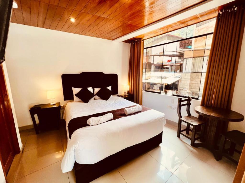 Un dormitorio con una cama grande y una ventana en SAYACMARCA CLASSIC Inn, en Machu Picchu