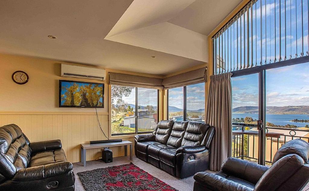 a living room with two chairs and a large window at Dromaius 6 in Jindabyne