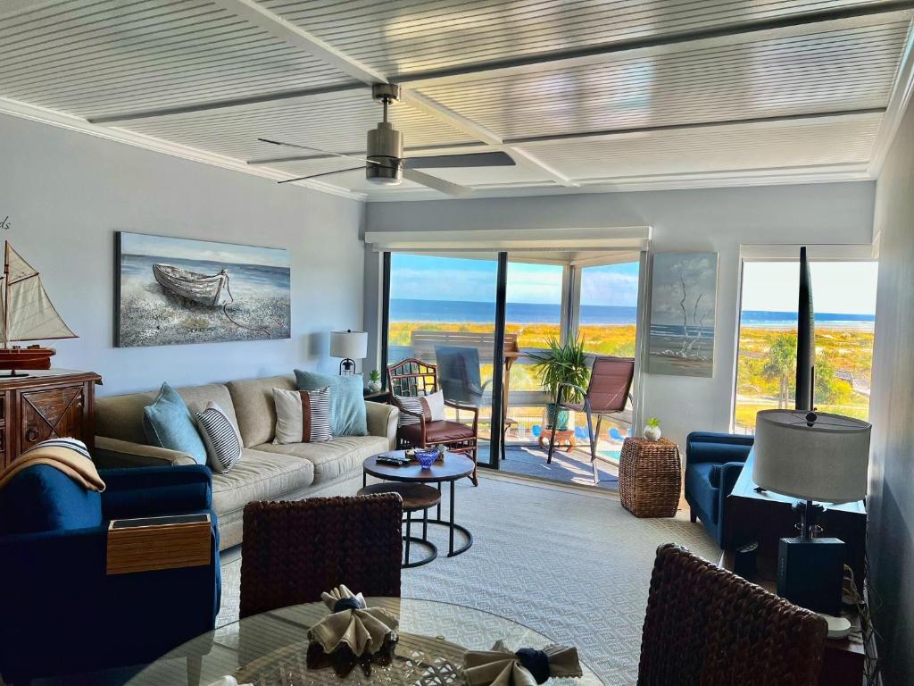 uma sala de estar com um sofá e uma mesa em Sandpiper SC Luxe Oceanview Condo in Private Paradise em Oceanmarsh Subdivision