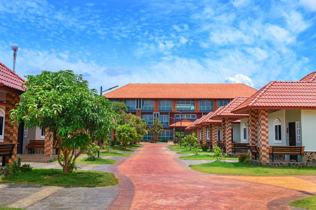 uma fila de edifícios com telhados vermelhos e uma estrada de terra em Avarin Resort em Pak Chong