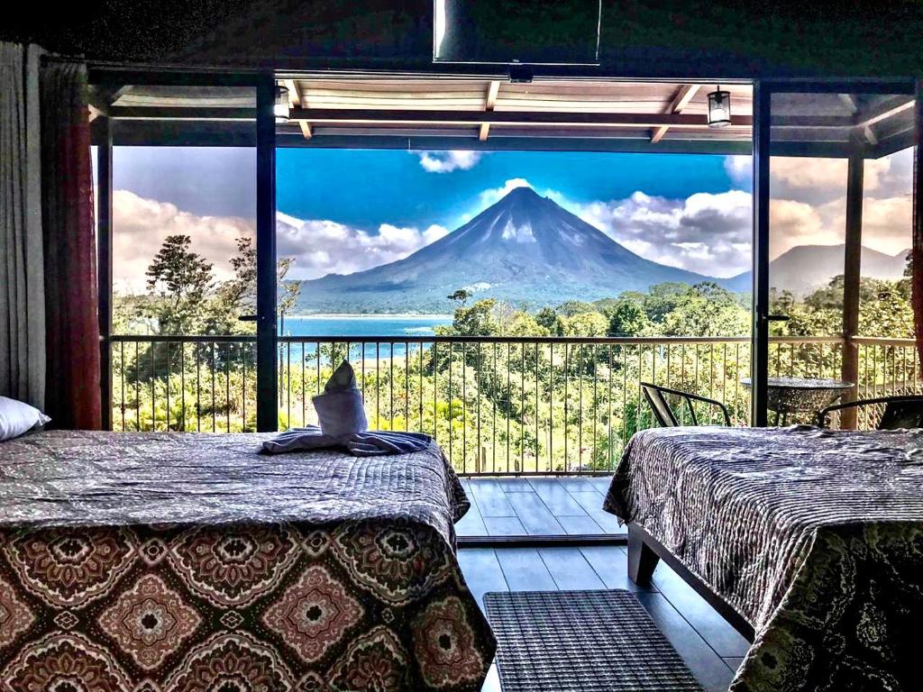 a view of a mountain from a room with two beds at Villas Paradise in El Castillo de La Fortuna