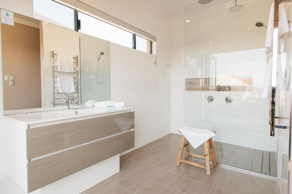 y baño con lavamanos, ducha y taburete. en Banksia by the Bay, en Emu Point