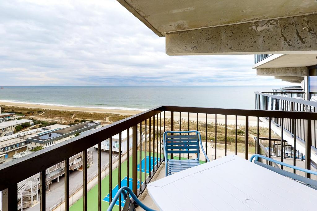 a balcony with a table and chairs and the beach at Sea Watch 1110 in Ocean City