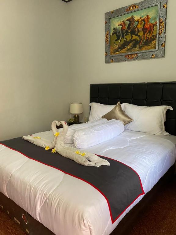 Postel nebo postele na pokoji v ubytování Guest House Pondok Puspa Ayu