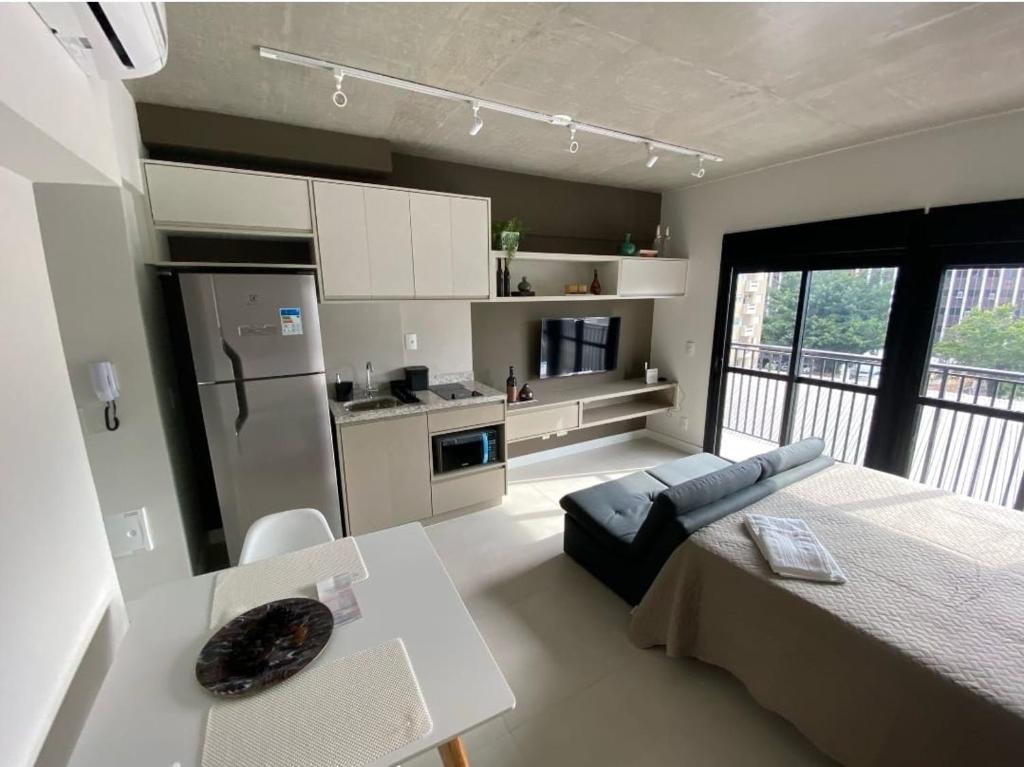 cocina y dormitorio con cama y mesa en 67 New studio in great location! Fast WI-FI, balcony, en São Paulo