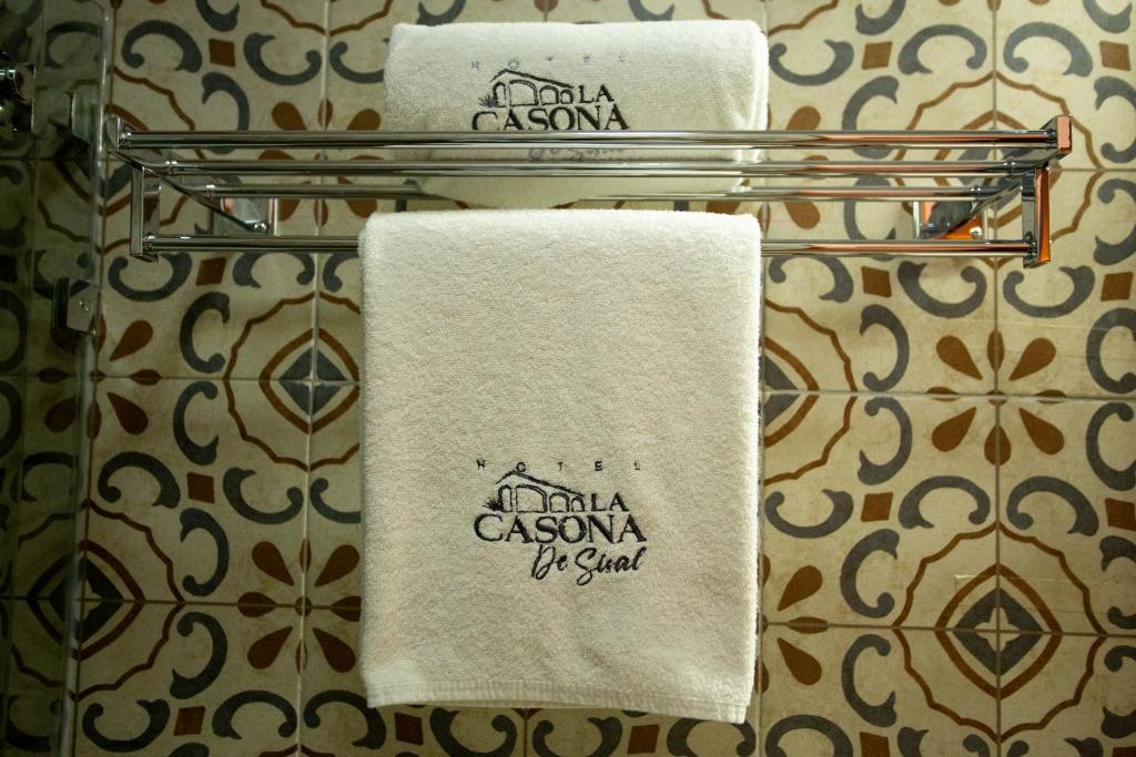 two towels on a towel rack in a bathroom at La Casona de Sisal Hotel in Sisal