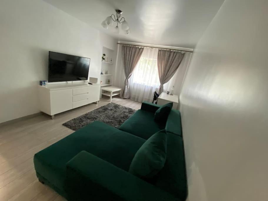 a living room with a green couch and a television at The Urban Hub 1 in Iaşi