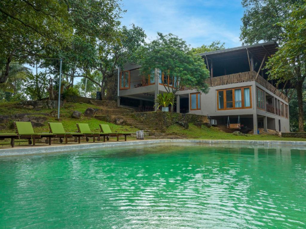 una casa con piscina frente a una casa en Birds Park Polgahawela en Egalla