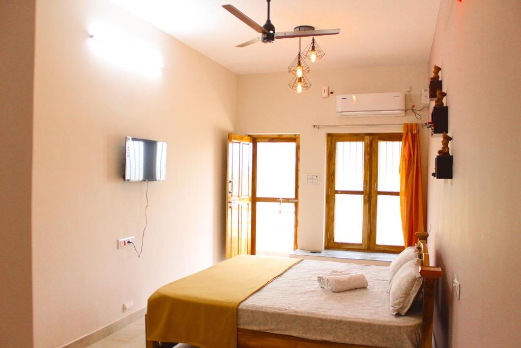 a bedroom with a bed and a window at Dwaraka Guest House in Tiruvannāmalai
