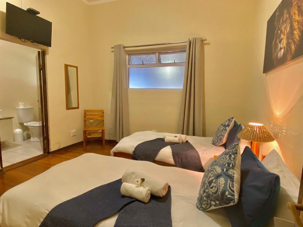 a bedroom with two beds with towels on them at The Mole Guesthouse in Swakopmund
