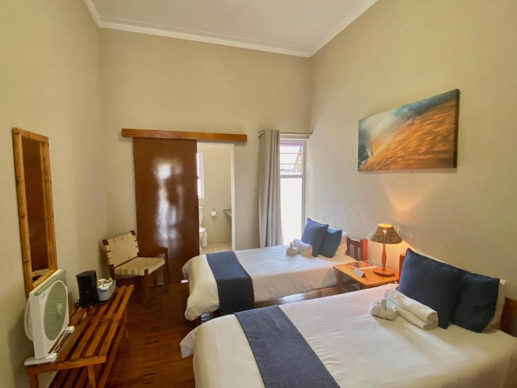 a hotel room with two beds and a tv at The Mole Guesthouse in Swakopmund