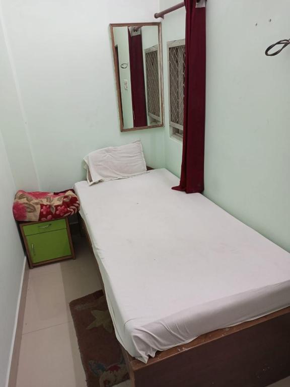 een kamer met 2 aparte bedden en een raam bij 7 Seas Guest House in Varanasi