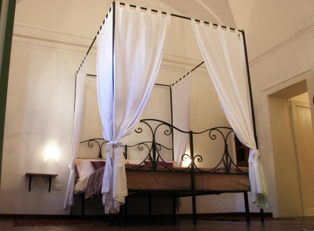 a canopy bed with white curtains in a bedroom at InChiostro Rooms&Breakfast in Padova