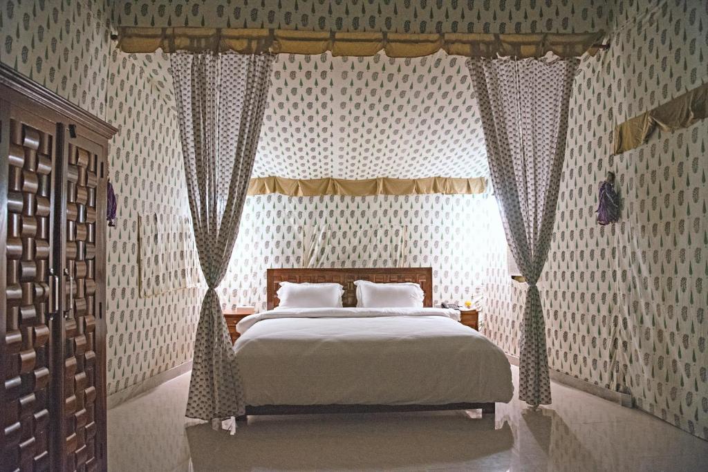 プシュカルにあるAtithi Camp & Resortのベッドルーム1室(天蓋付きの大型ベッド1台付)