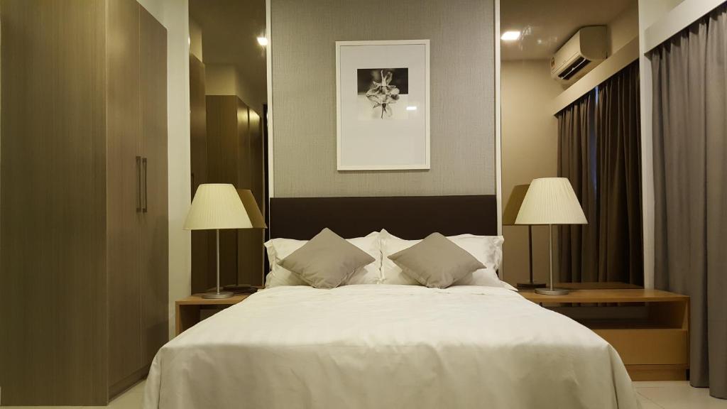 a bedroom with a large white bed with two lamps at One Tebrau by Iconic Bliss in Johor Bahru