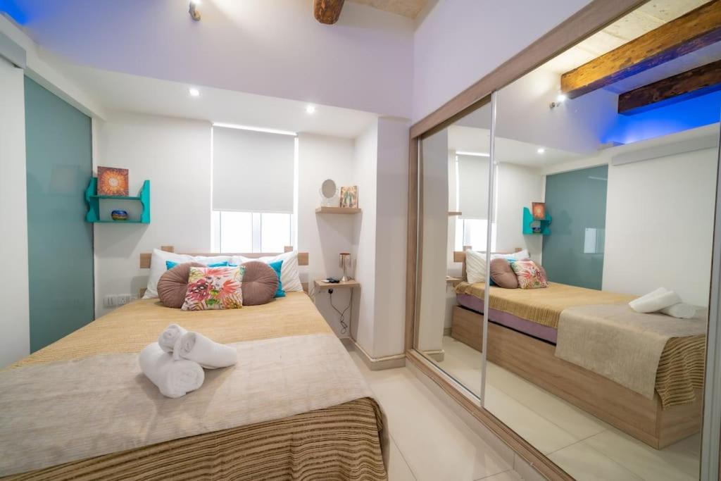 a bedroom with two beds and a glass wall at JBO- Joette's Bliss Oasis in Valletta